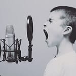 Boy yelling into microphone