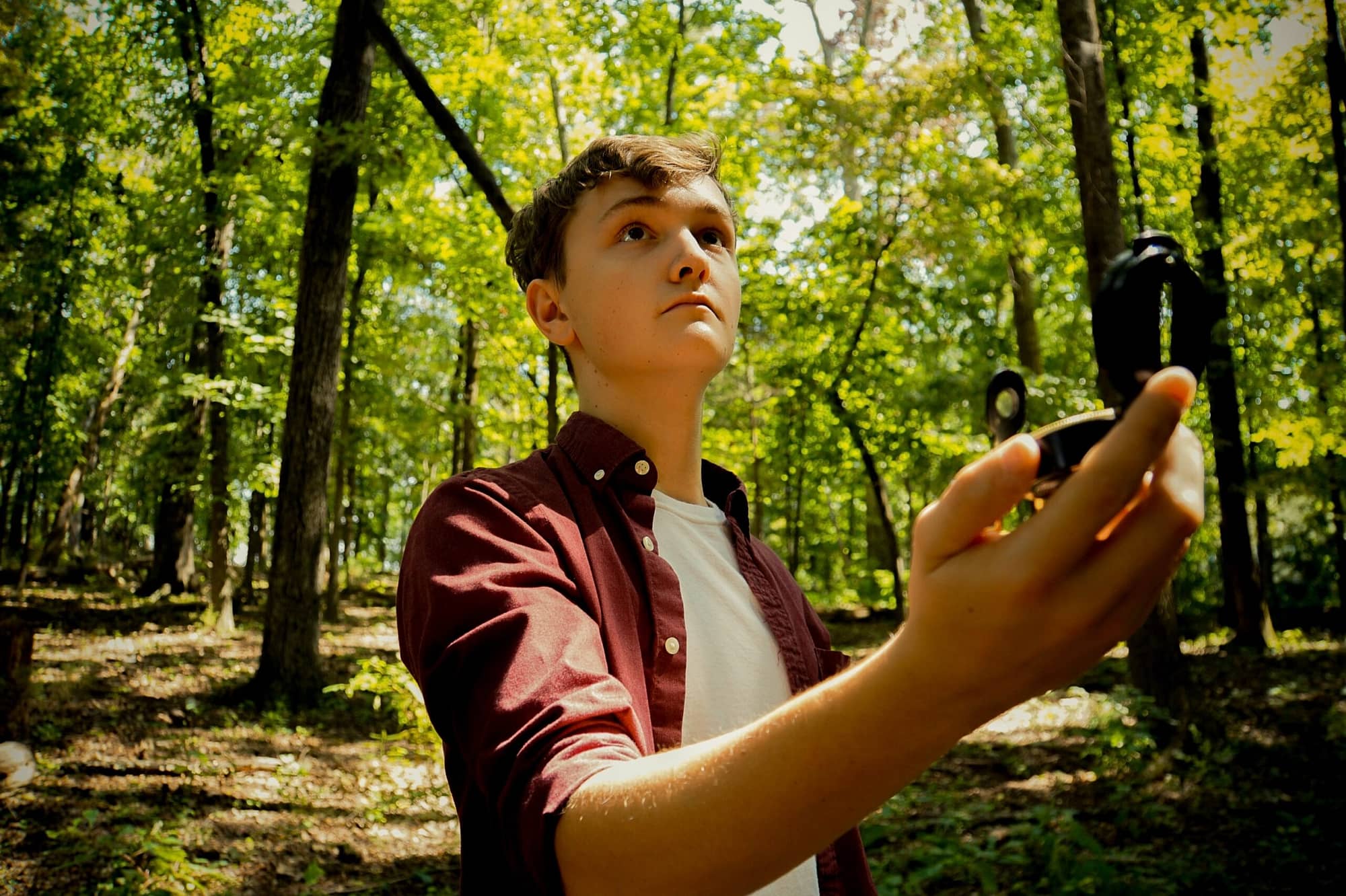 freelancer in woods searching with compass